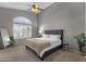 Spacious primary bedroom with large arched windows, neutral colors, plush carpet, and a ceiling fan at 20239 N 39Th Dr, Glendale, AZ 85308