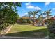 Expansive backyard with lush greenery, mature palm trees, rock waterfall feature in pool, and secure block wall, ideal for private enjoyment at 2103 E Canyon Pl, Chandler, AZ 85249