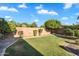 Spacious backyard featuring lush green lawn, mature trees, and block wall fencing for privacy, creating a serene outdoor oasis at 2103 E Canyon Pl, Chandler, AZ 85249