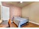Bedroom featuring a brick accent wall, industrial style bed frame and hardwood floors at 2103 E Canyon Pl, Chandler, AZ 85249