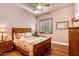 Bedroom with a wooden bed and matching nightstands, wood floors, ceiling fan, and plantation shutters at 2103 E Canyon Pl, Chandler, AZ 85249