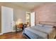 Bedroom with a brick accent wall, desk, and doorway to an ensuite bathroom at 2103 E Canyon Pl, Chandler, AZ 85249