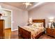 Bedroom features a wooden bed and matching nightstands, wood floors, ceiling fan, and a closet entrance at 2103 E Canyon Pl, Chandler, AZ 85249