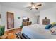 Bright bedroom featuring wood floors, a ceiling fan, and a television above a wooden dresser at 2103 E Canyon Pl, Chandler, AZ 85249
