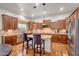 This kitchen features a granite island with seating, modern stainless appliances, tile backsplash, and hardwood flooring at 2103 E Canyon Pl, Chandler, AZ 85249