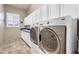 Bright laundry room with white cabinets, granite countertop, front loading washer and dryer at 2103 E Canyon Pl, Chandler, AZ 85249