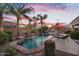 Stunning backyard pool with palm trees, a waterfall feature, patio furniture, and evening sky at 2103 E Canyon Pl, Chandler, AZ 85249