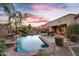 Backyard oasis features a pool with waterfall, lounge chairs, and lush landscaping, perfect for relaxation at 2103 E Canyon Pl, Chandler, AZ 85249