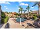 Inviting swimming pool surrounded by lush landscaping, featuring a red umbrella, lounge chairs, and an in-pool step for easy access at 2103 E Canyon Pl, Chandler, AZ 85249