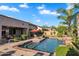 Gorgeous swimming pool and spa featuring lush landscaping, a red umbrella, and easy access steps for ultimate relaxation at 2103 E Canyon Pl, Chandler, AZ 85249