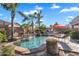 Refreshing swimming pool featuring lush landscaping, including palm trees and green bushes, and a rock waterfall, perfect for outdoor living at 2103 E Canyon Pl, Chandler, AZ 85249