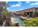 Amazing swimming pool surrounded by lush greenery, featuring a covered patio and outdoor kitchen in a serene backyard setting at 2103 E Canyon Pl, Chandler, AZ 85249