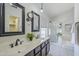 Bathroom featuring a double vanity, framed mirrors, and glass-enclosed shower and tub at 2135 S Bristol --, Mesa, AZ 85209