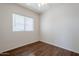 Minimalist bedroom with a ceiling fan, wood floors, and a large window for plenty of natural light at 2135 S Bristol --, Mesa, AZ 85209