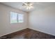 Bright bedroom with dark laminate flooring, a ceiling fan, and a large window at 2135 S Bristol --, Mesa, AZ 85209