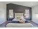Main bedroom featuring stylish decor, with accent wall and matching side tables at 2135 S Bristol --, Mesa, AZ 85209