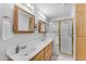 Bright bathroom with double sinks, wood cabinets and a glass door shower stall at 22609 S 214Th Way, Queen Creek, AZ 85142