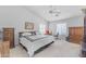 Bright primary bedroom with a ceiling fan, dresser and a large bed with a black and white comforter at 22609 S 214Th Way, Queen Creek, AZ 85142