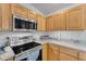 Modern kitchen featuring stainless steel appliances, including a microwave, oven, and cooktop at 22609 S 214Th Way, Queen Creek, AZ 85142