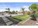 Backyard view features a pool, grass, pavers, tropical plants, and block walls, creating a peaceful outdoor area at 23097 N 95Th Dr, Peoria, AZ 85383