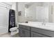 Contemporary-style bathroom features gray vanity, solid surface countertop, framed mirror, and tub with a dark shower curtain at 23097 N 95Th Dr, Peoria, AZ 85383