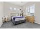 Comfortable carpeted bedroom with natural light, a bed with a gray and white zigzag comforter and natural wood furniture at 23097 N 95Th Dr, Peoria, AZ 85383