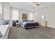Bright bedroom features a ceiling fan, large window, and comfortable carpet at 23097 N 95Th Dr, Peoria, AZ 85383