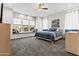 Bright bedroom features a ceiling fan, large window, and comfortable carpet at 23097 N 95Th Dr, Peoria, AZ 85383