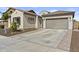 Home with a spacious driveway and a two-car garage, complemented by desert landscaping and neutral tones at 23097 N 95Th Dr, Peoria, AZ 85383