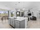 Open-concept kitchen with white quartz countertops, stainless steel appliances, an island with bar stools, and seamless flow at 23097 N 95Th Dr, Peoria, AZ 85383