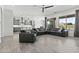 Open-concept living room with contemporary furniture, tile flooring, and seamless flow to the kitchen and dining area at 23097 N 95Th Dr, Peoria, AZ 85383