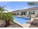 Backyard pool area, including a pool, patio, palm trees, and chairs, creates a tranquil and relaxing retreat at 23097 N 95Th Dr, Peoria, AZ 85383