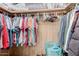 Walk-in closet with wooden shelves and clothes hanging on hangers at 245 S 56Th St # 135, Mesa, AZ 85206