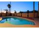 Inviting pool area surrounded by tall palm trees and ambient lighting, creating a private desert retreat at 3054 W Redfield Rd, Phoenix, AZ 85053