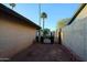 Exterior side yard with brick retaining wall, mature trees, and privacy gate at 3054 W Redfield Rd, Phoenix, AZ 85053