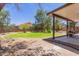 Beautiful backyard featuring a covered patio, lush green grass and stone landscaping at 33287 N Windmill Run, San Tan Valley, AZ 85144