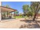 Lush backyard with a covered patio, green lawn, and desert landscaping at 33287 N Windmill Run, San Tan Valley, AZ 85144