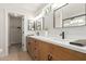 The bathroom boasts a dual sink vanity, black hardware, and a view into the walk-in closet for added convenience at 33287 N Windmill Run, San Tan Valley, AZ 85144