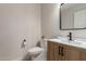 Modern half bathroom featuring a wood vanity, matte black fixtures, and a sleek mirror at 33287 N Windmill Run, San Tan Valley, AZ 85144