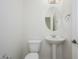 Powder room featuring a pedestal sink, toilet, and a decorative mirror at 3361 E Wisteria Pl, Chandler, AZ 85286