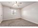 Bedroom features neutral carpet, a ceiling fan, and a window with shutter blinds at 3825 E Camelback Rd # 290, Phoenix, AZ 85018