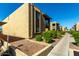 Tan stucco building with green bushes, rock landscaping and a concrete walkway at 3825 E Camelback Rd # 290, Phoenix, AZ 85018