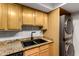 Kitchen sink and counter with stacked washer and dryer and light wood cabinets at 3825 E Camelback Rd # 290, Phoenix, AZ 85018