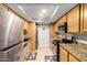 Kitchen featuring stainless steel appliances, granite countertops, and wooden cabinetry at 3825 E Camelback Rd # 290, Phoenix, AZ 85018