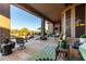 Expansive back patio featuring stone flooring, comfortable seating, lush landscaping, and serene views of the pool at 40619 N Candlewyck Ln, Phoenix, AZ 85086