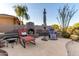 Outdoor fireplace with chairs for relaxing, spacious patio area, landscaped yard and desert-style backyard at 40619 N Candlewyck Ln, Phoenix, AZ 85086