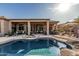 Backyard features pool, covered patio, lounge areas, built-in grill and desert landscaping at 40619 N Candlewyck Ln, Phoenix, AZ 85086
