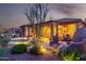 Expansive backyard showcases a shimmering pool, covered patio, lush landscaping, and serene desert surroundings at 40619 N Candlewyck Ln, Phoenix, AZ 85086