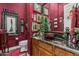 Unique powder room features bold red walls, dark granite countertop, vessel sink, and eclectic wall art at 40619 N Candlewyck Ln, Phoenix, AZ 85086