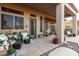 Covered patio featuring stone flooring, comfortable seating, and access to the lush landscaped backyard at 40619 N Candlewyck Ln, Phoenix, AZ 85086